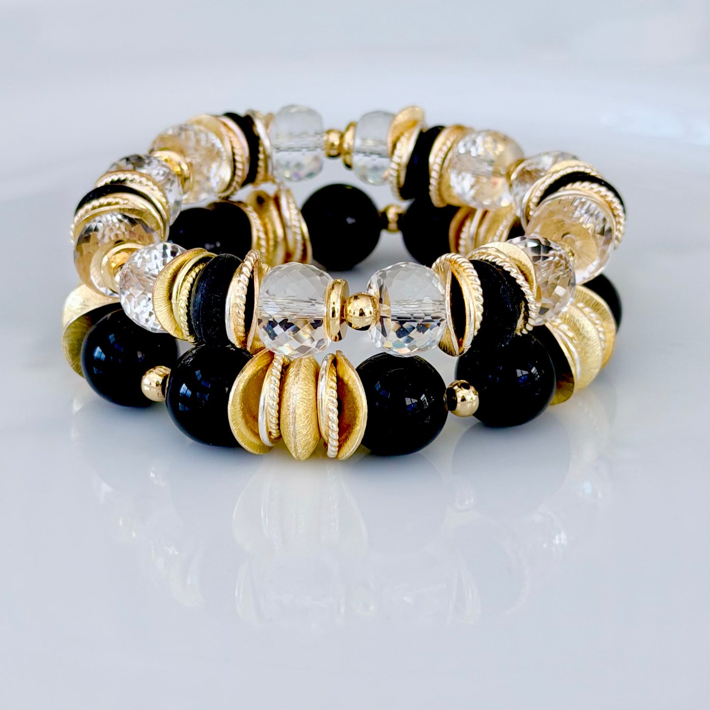 FACETED LUCITE BANGLE WITH GOLD, WAVY DISC AND BLACK ACCENTS