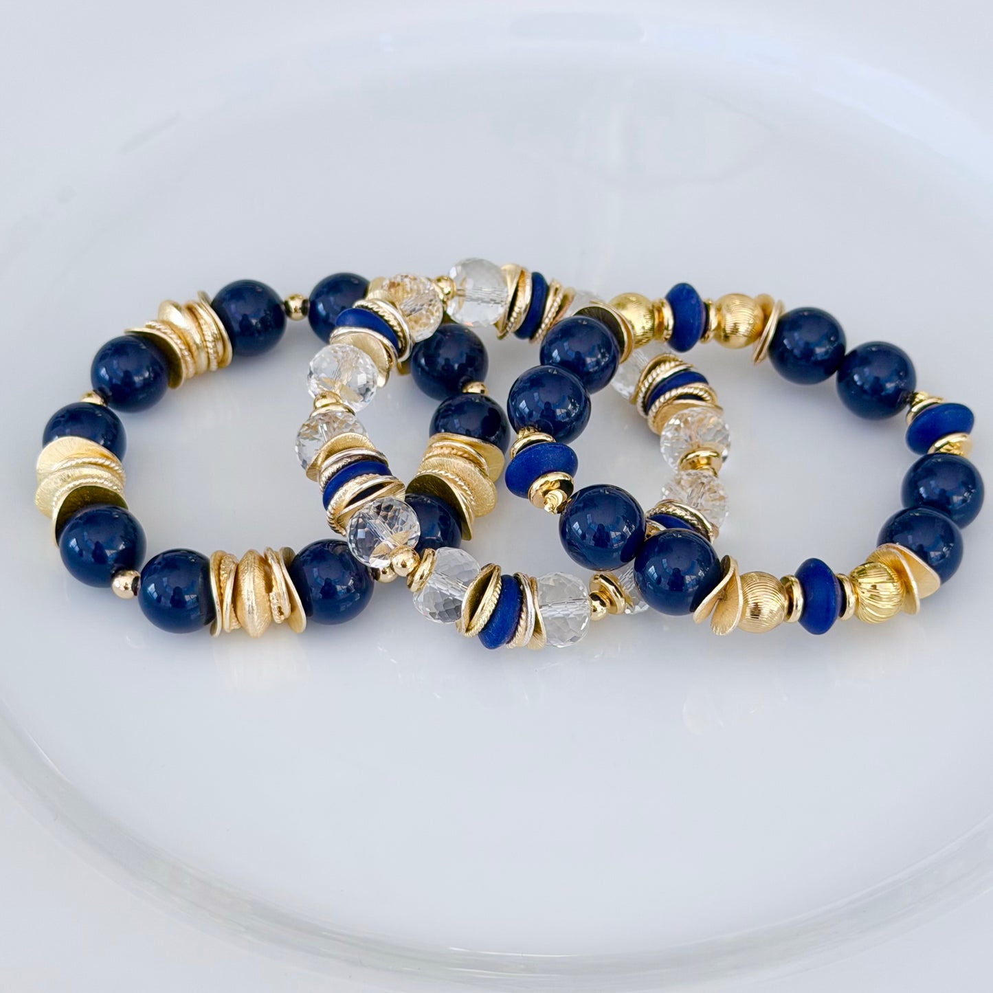 FACETED LUCITE BANGLE WITH GOLD, WAVY DISC AND NAVY BLUE ACCENTS