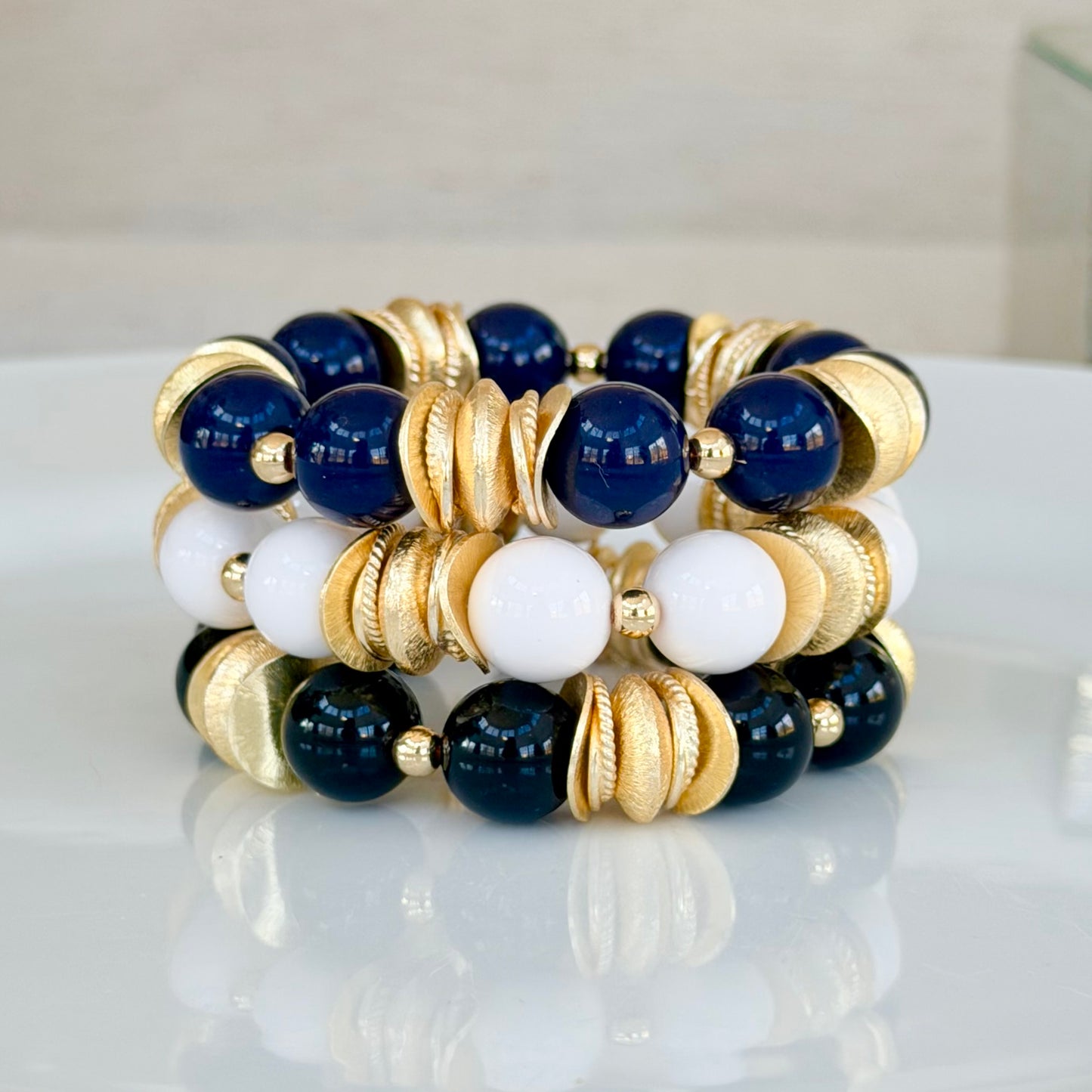 NAVY BLUE BANGLE WITH BRUSHED GOLD WAVY DISC AND GOLD ACCENTS