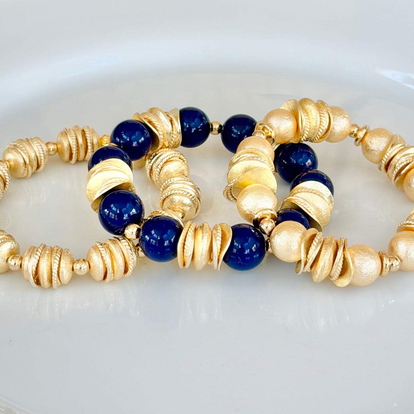 NAVY BLUE BANGLE WITH BRUSHED GOLD WAVY DISC AND GOLD ACCENTS