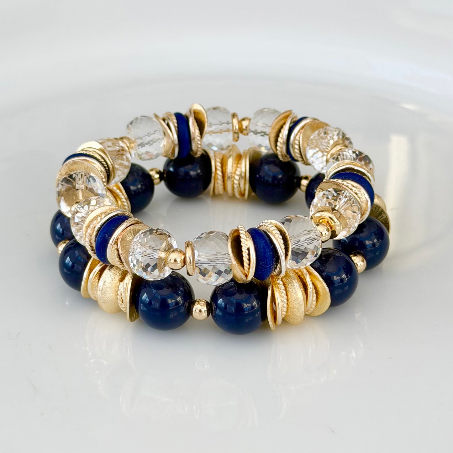 FACETED LUCITE BANGLE WITH GOLD, WAVY DISC AND NAVY BLUE ACCENTS